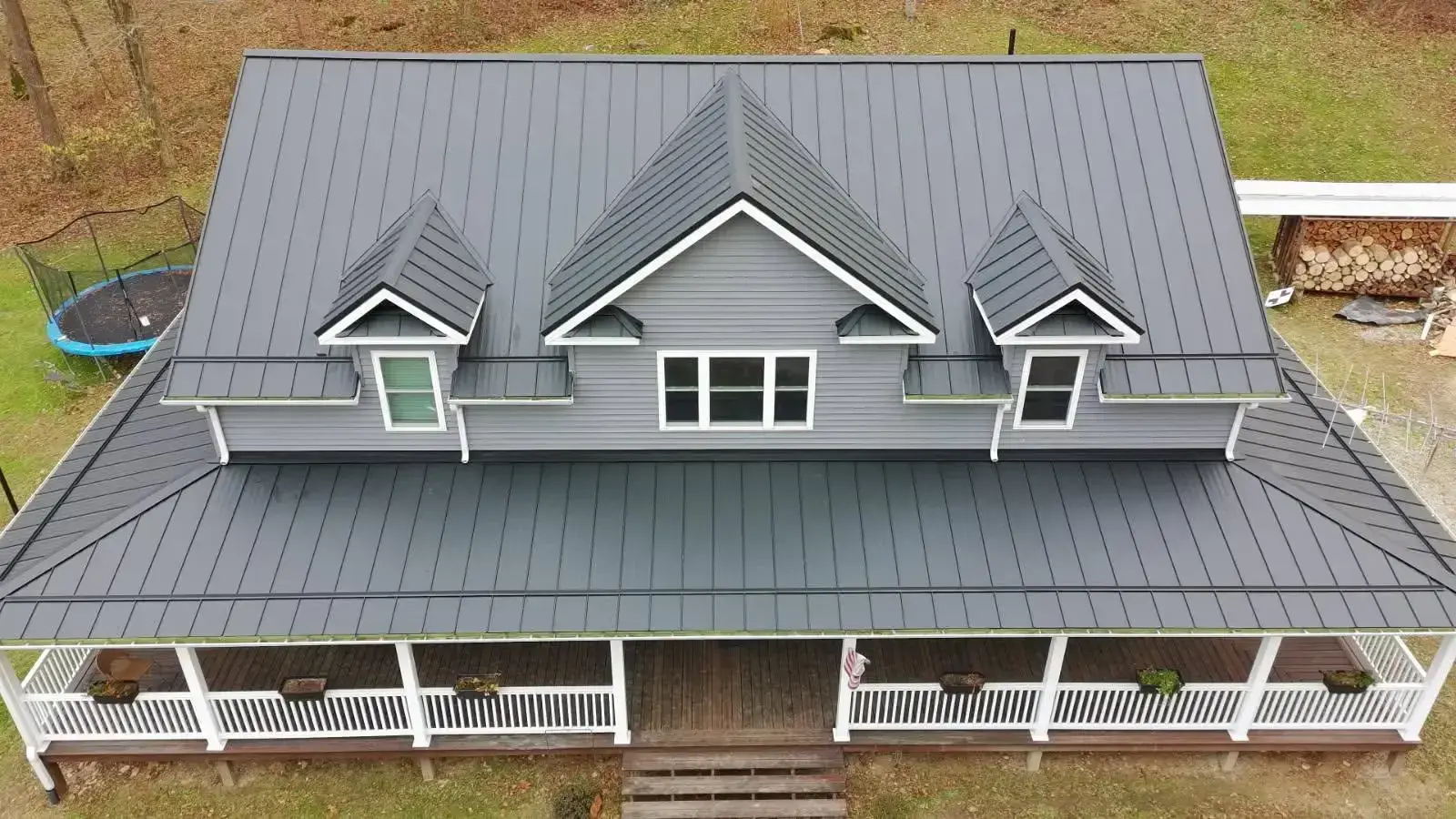Aerial view of a dark grey standing seam metal roof with dormers on an Ohio farmhouse
