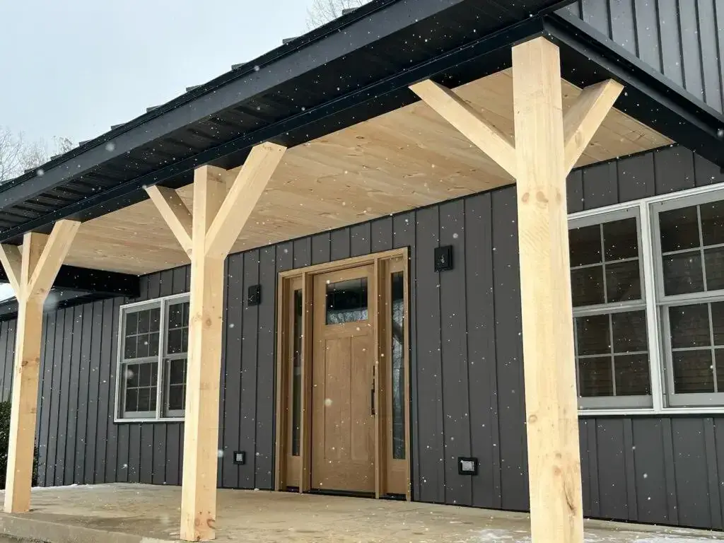 Charcoal metal roof and board and batten siding during an Ohio snowfall
